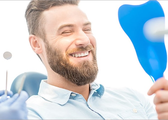 man at the dentist looks in the mirror